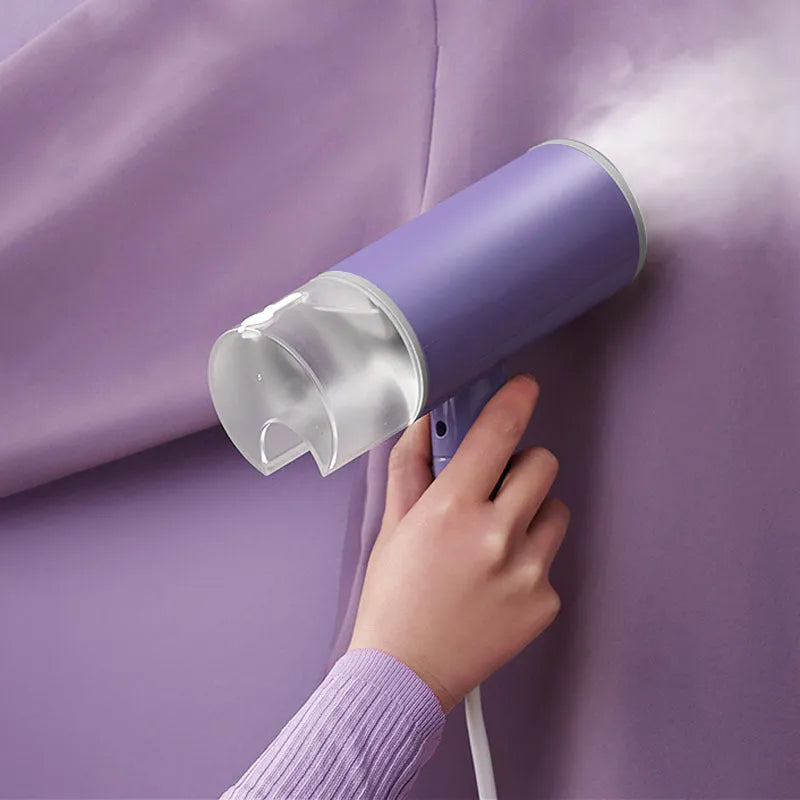 Portable handheld garment steamer in grey lotus root purple colour, shown with foldable design and water filling opening.