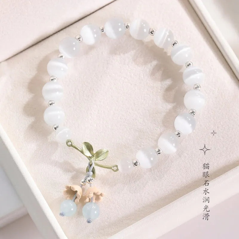 Women's bracelet with multiple diamond-shaped cat's eye opal beads on a string.