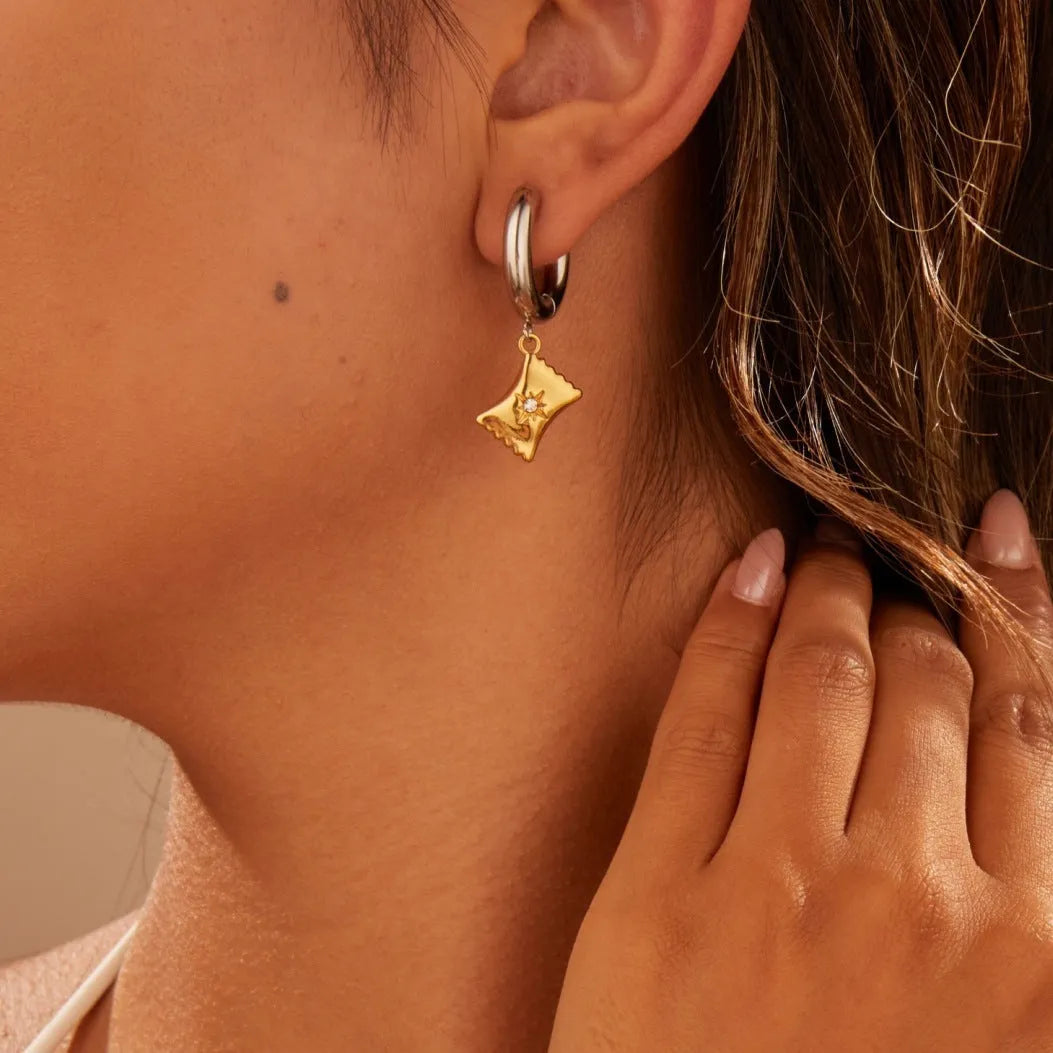 A pair of stainless steel Christmas tree and heart shaped earrings with 18K gold electroplating.