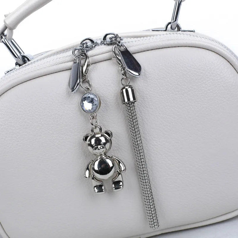 Oval-shaped women's small square bag in PU with double shoulder strap and internal phone pocket.