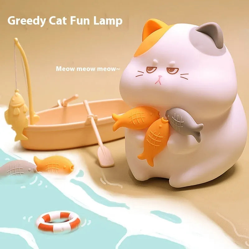 Small yellow Greedy Cat cartoon desktop night light with socket plug on desk.