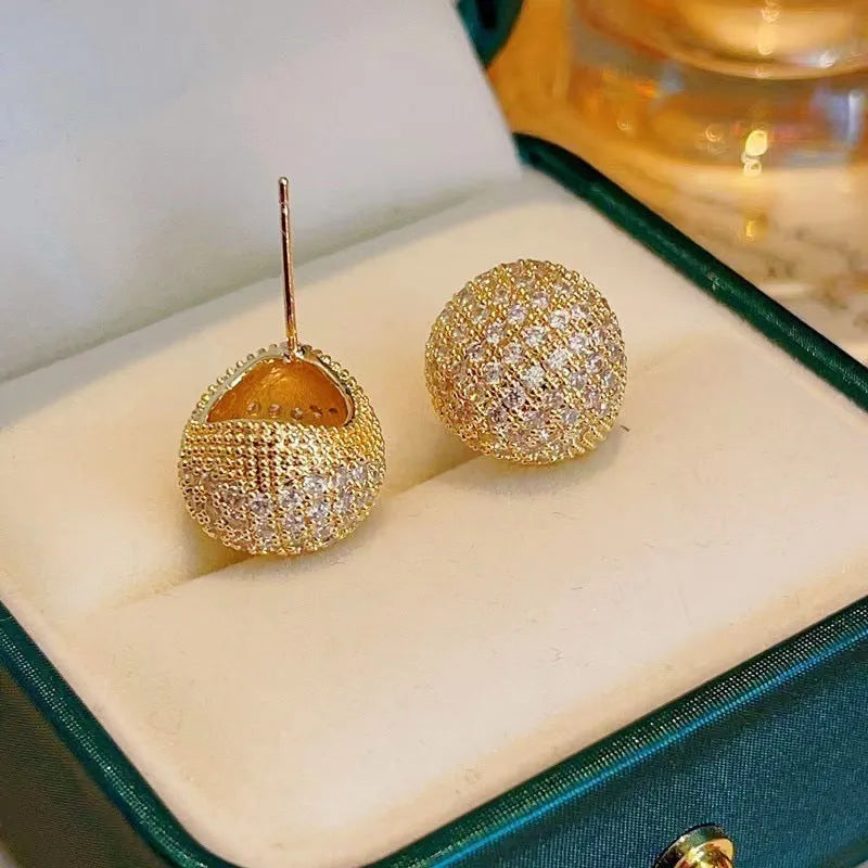 Drop-shaped geometric ear clips with full diamond setting and sphere elements in gold and white finishes
