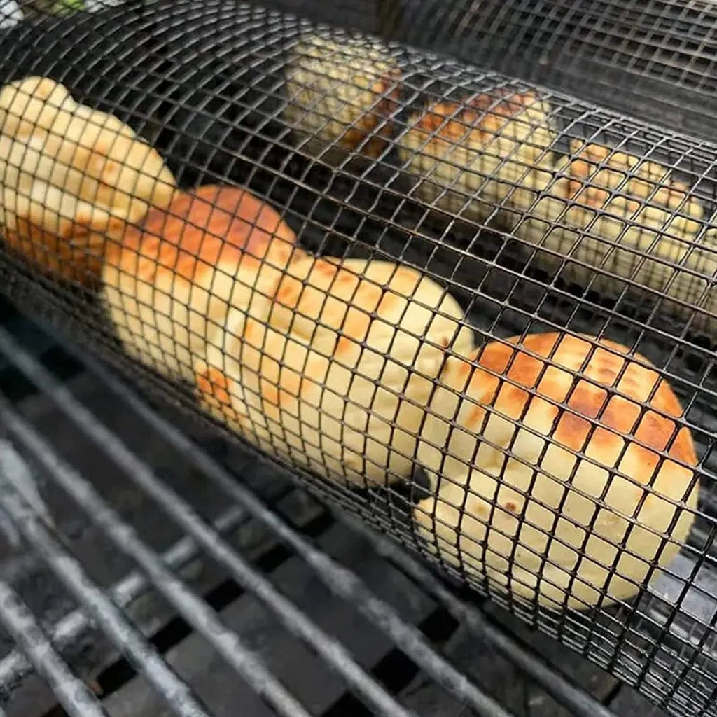 Stainless steel cylindrical rolling grill basket for BBQ with wire mesh, shown with vegetables inside.