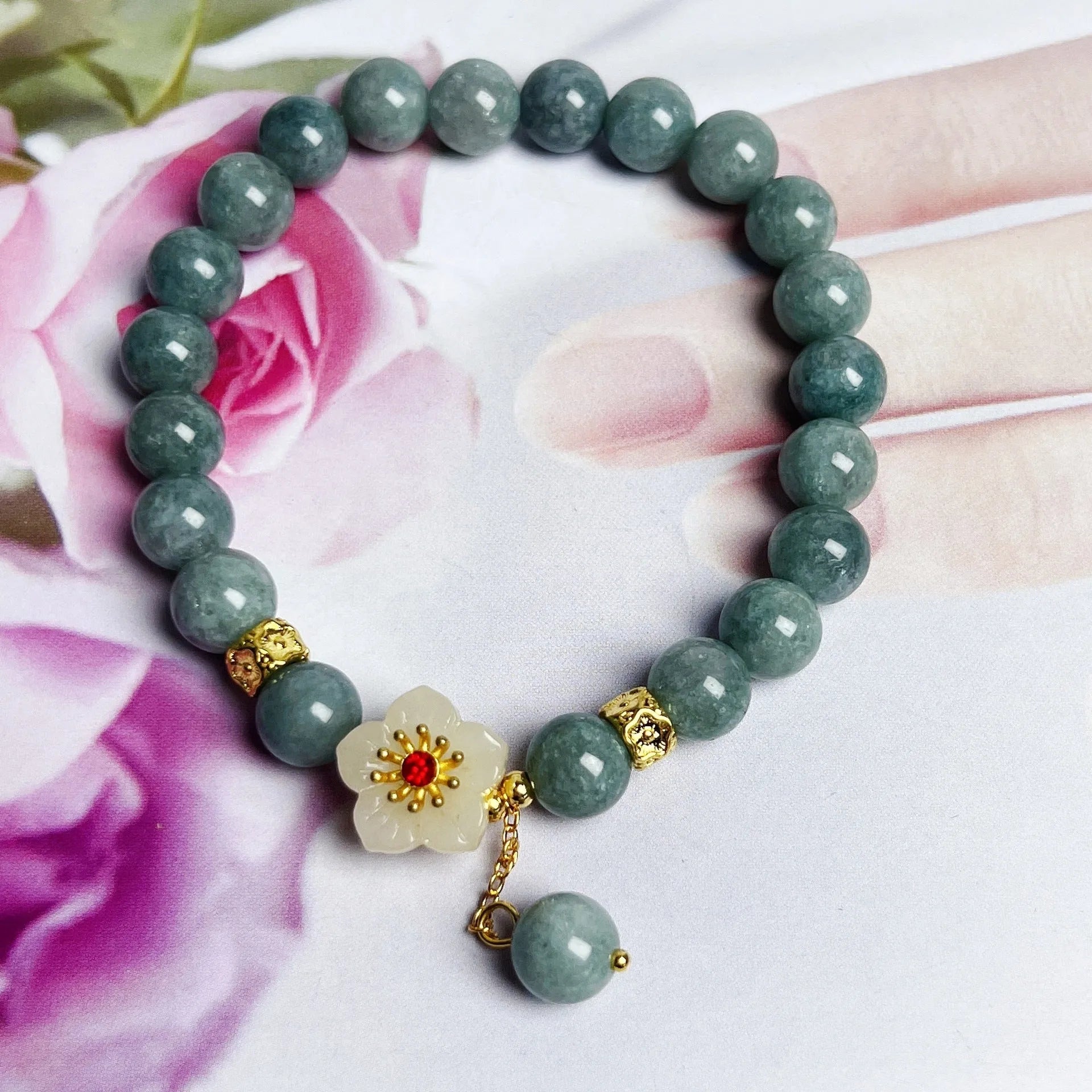 Handmade green jade bracelet with adjustable cotton cord fastening on a wrist.