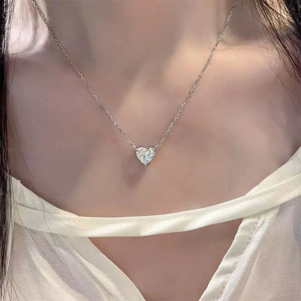 Simple silver-coloured women's necklace with a small love heart pendant on a chain.