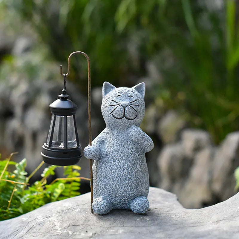 Solar garden light featuring a resin sculpture of a kitten holding up a lantern.
