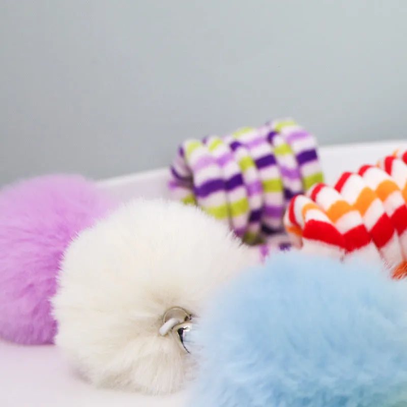 Kitten spring toy with blue inflatable ball hanging from suction cup on glass door