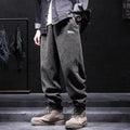 Man wearing grey ankle-tie sweatpants, showing the straight leg and adjustable cuff detail.