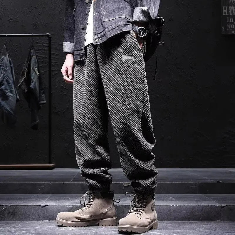 Man wearing grey ankle-tie sweatpants, showing the straight leg and adjustable cuff detail.