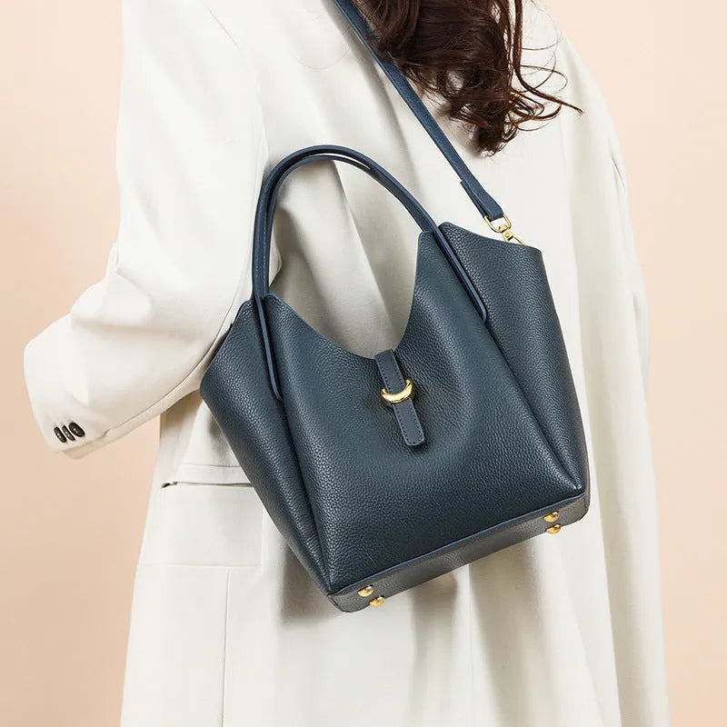 Genuine leather women's retro bucket handbag in beige with sewn detailing and an outer pocket.