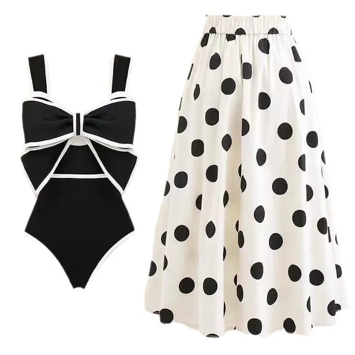 Women's black one-piece swimsuit with matching beach dress featuring bow and round skirt design