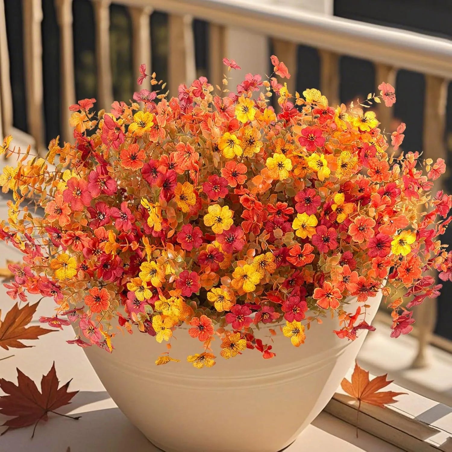 Artificial flower bouquet in autumn colours of red, yellow, and orange for home and event decoration.