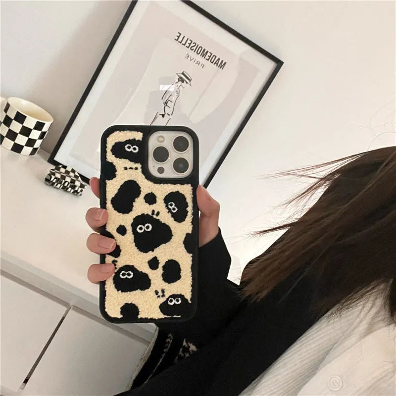 Black plush fairy-themed funny back cover case for iPhone on a table