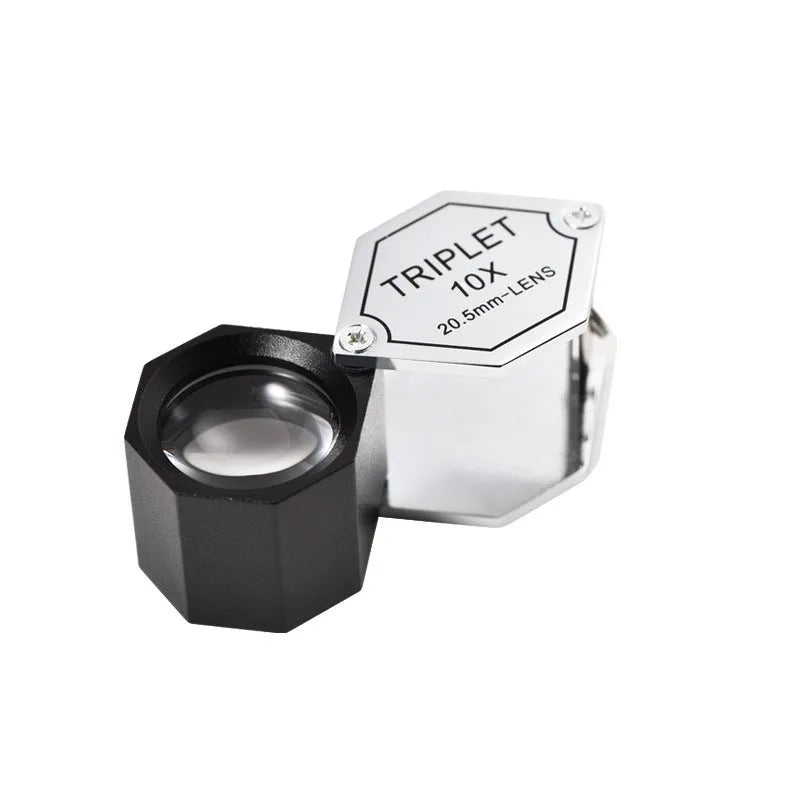Handheld metal and optical glass magnifying loupe for jewellery and coin inspection.