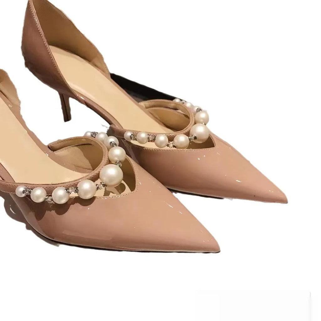 Women's pointed toe patent leather stiletto high heels with pearl decoration on the upper.