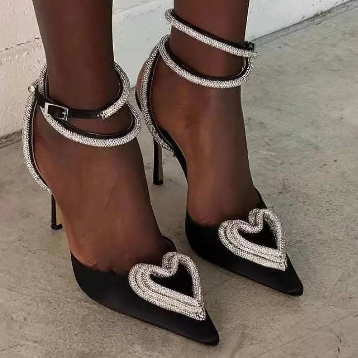 Women's pink satin sandals with pointed toe, heart-shaped rhinestones, and 9.5cm heel on a rubber sole.
