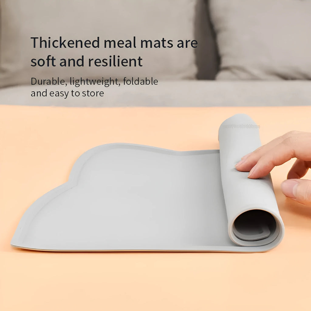 Blue cat head shaped silicone pet feeding mat placed under food and water bowls.