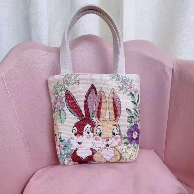 Gold wire embroidered canvas handbag showing bunny design, with polyester lining and top handles.