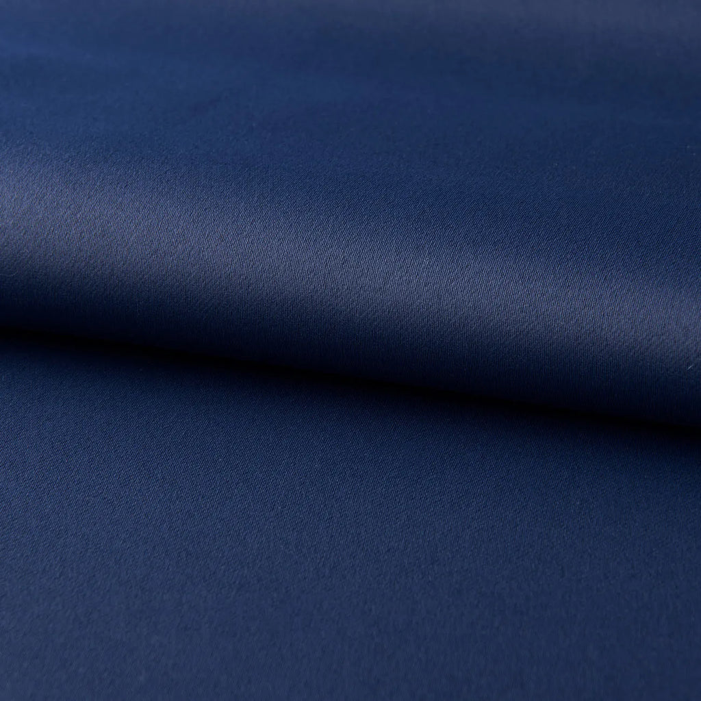 Navy blue blackout curtains with shading cloth fabric in vertical design, showing printed surface and perforated top for hanging