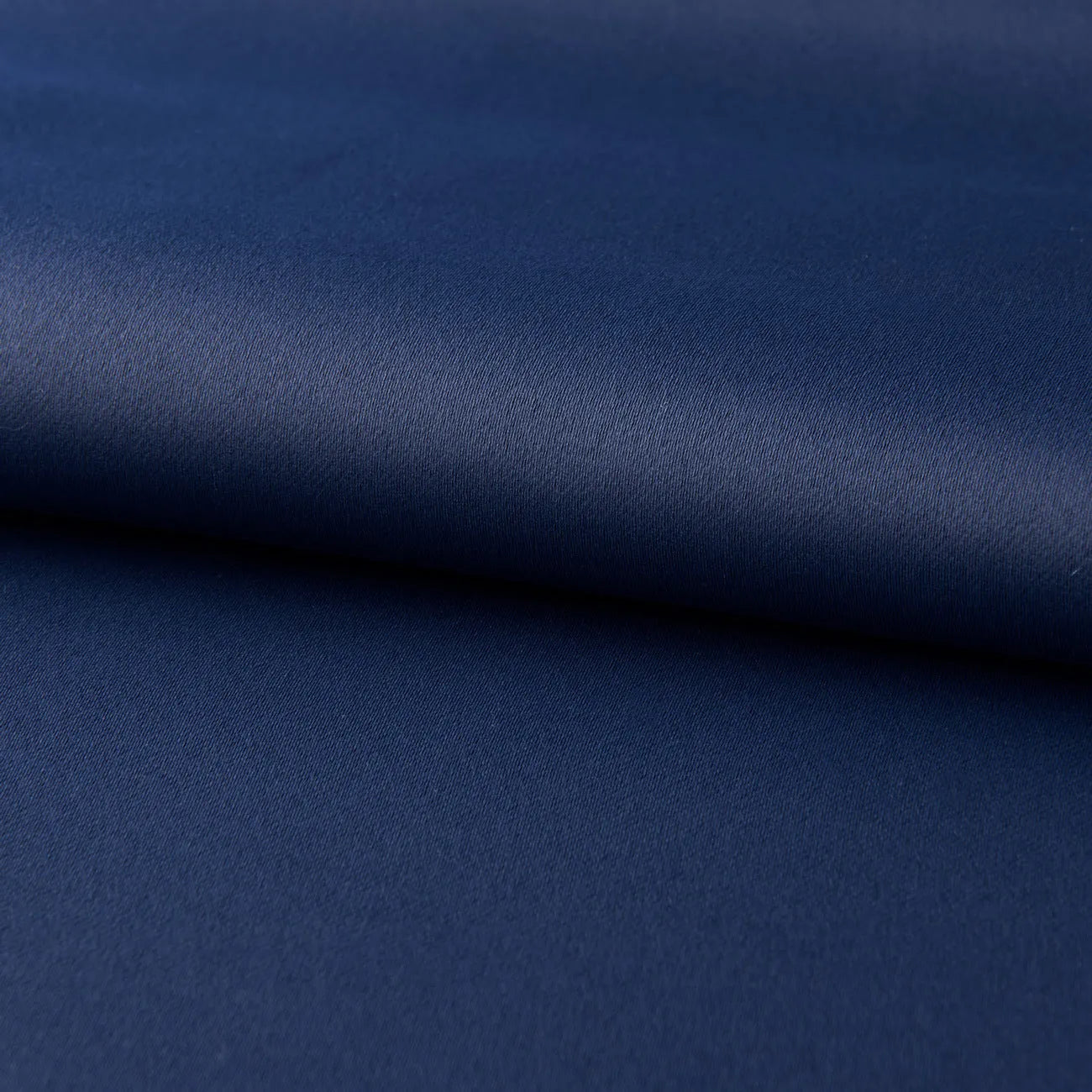 Navy blue blackout curtains with shading cloth fabric in vertical design, showing printed surface and perforated top for hanging