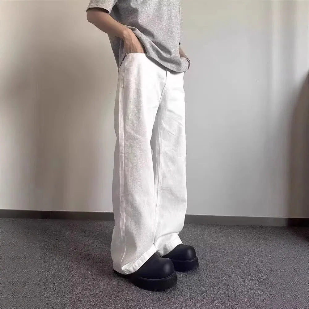 Men's straight-leg white denim jeans with mid-waist and zipper fly, shown in a summer setting.
