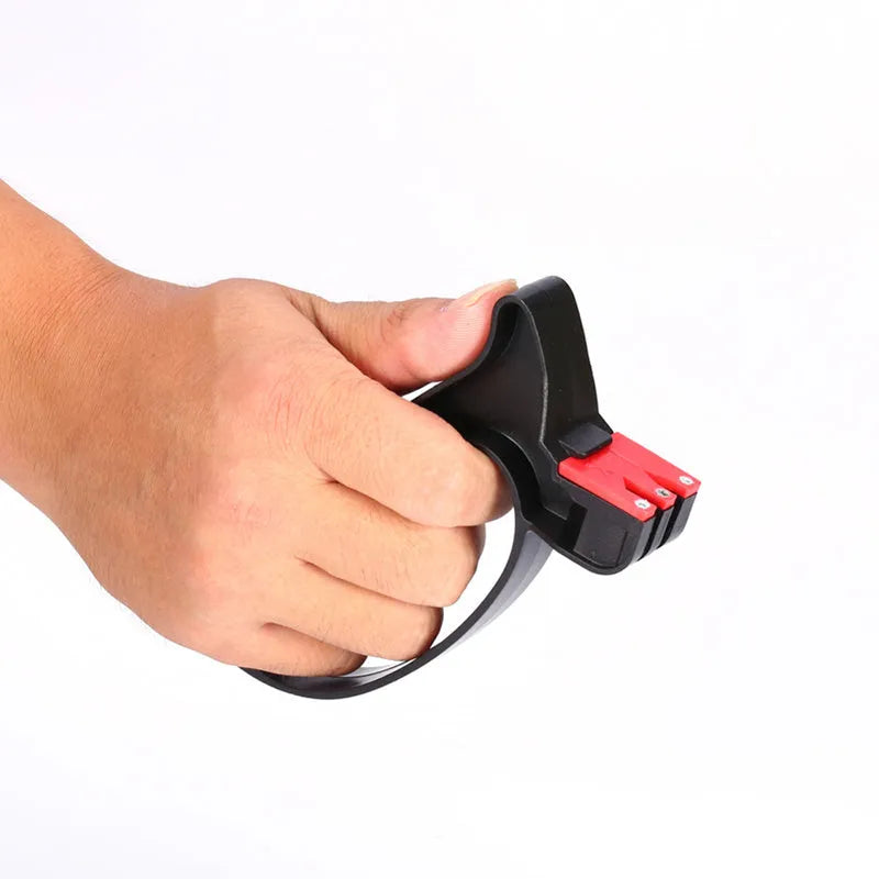 Black handheld tungsten steel knife and scissor sharpener on a kitchen counter