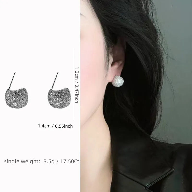 Drop-shaped geometric ear clips with full diamond setting and sphere elements in gold and white finishes