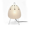 Japanese style rice paper table lamp with aluminium base on a wooden surface.
