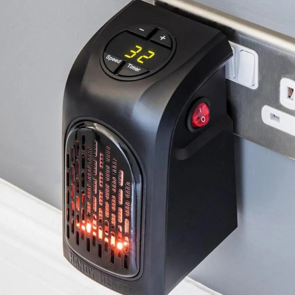 Small black ceramic fan heater with mechanical controls on a desk.