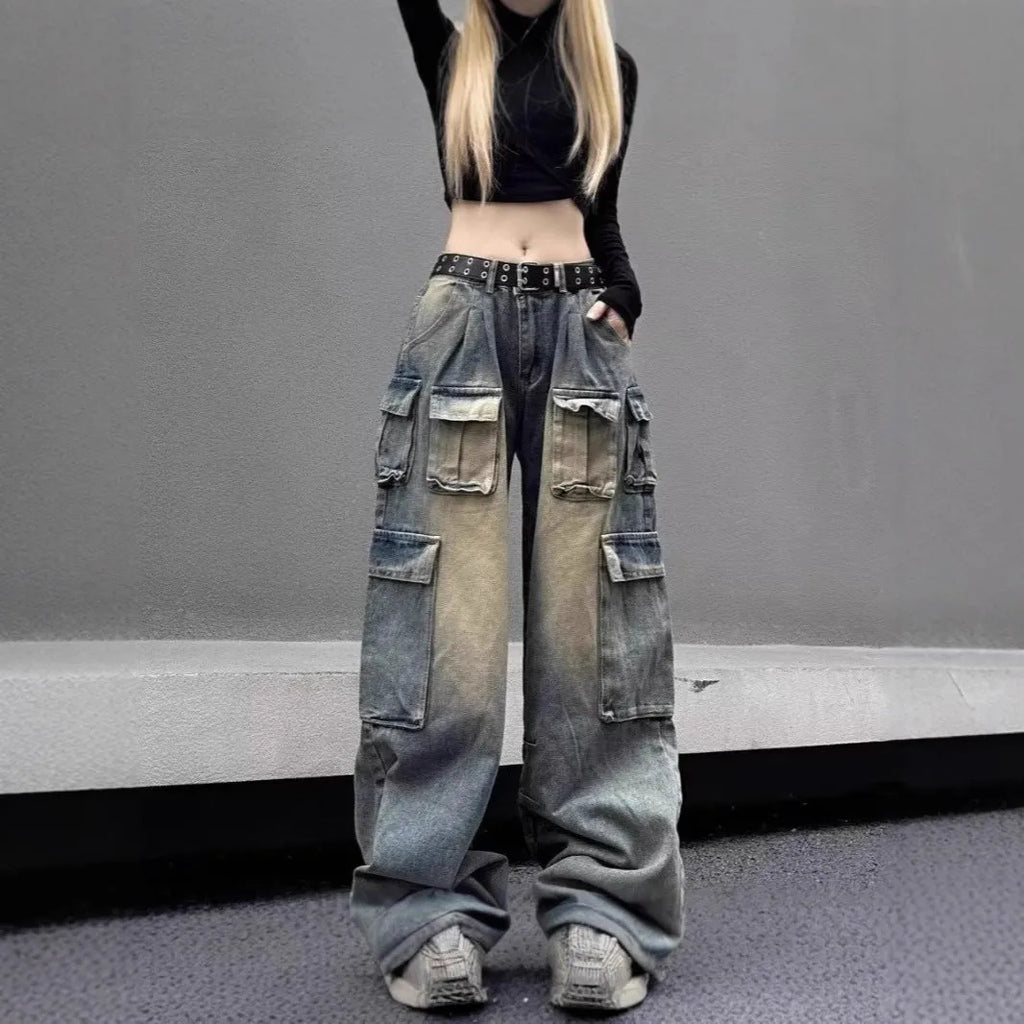 Man wearing light blue loose fit distressed jeans with multiple pockets and straight leg style.