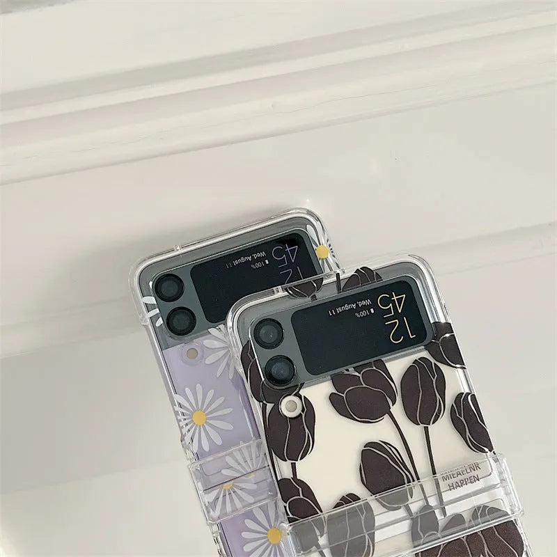 Clear Samsung Galaxy Z Flip phone case with floral pattern, available in Daisy and Tulip designs.