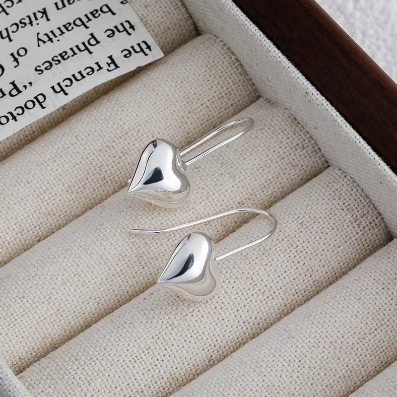 Heart-shaped copper earrings with white gold plating and glossy finish, showing three-dimensional design