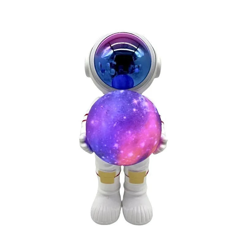Spaceman-themed starry sky projection lamp with Bluetooth speaker on a bedside table.