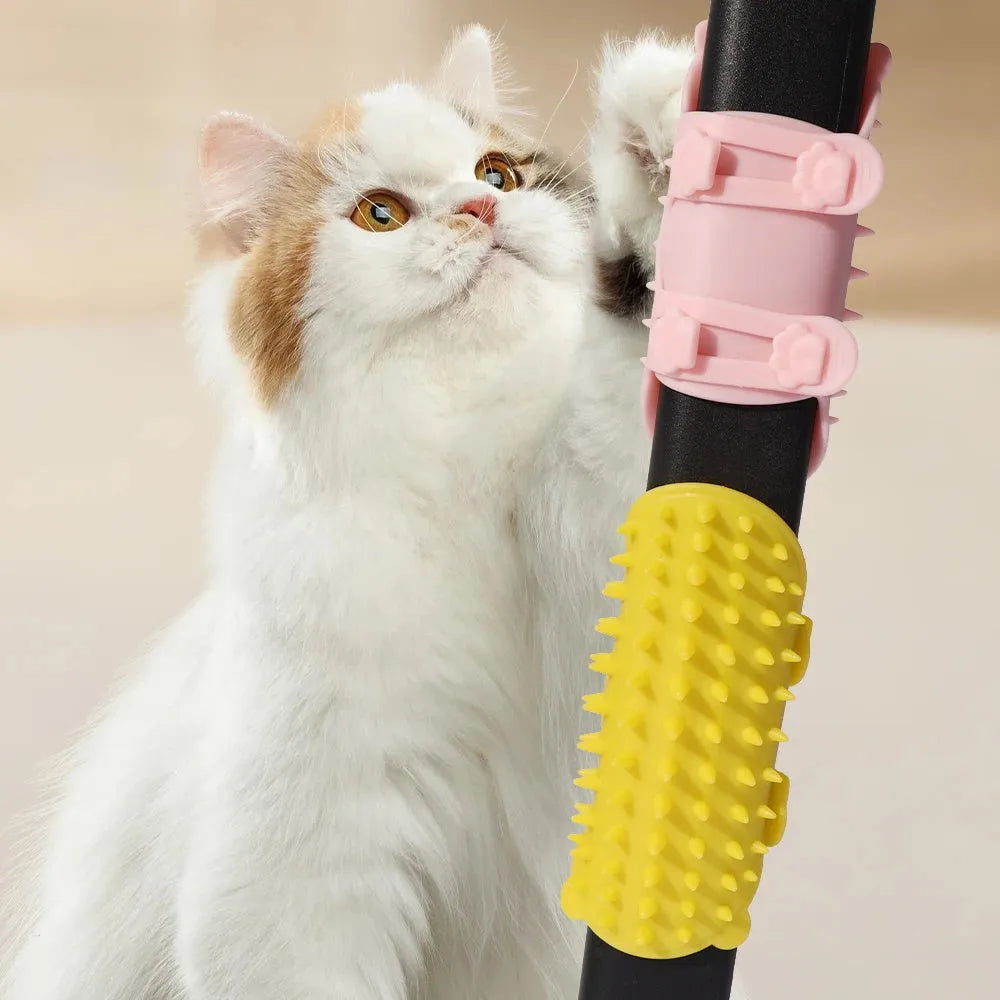 Black silicone cat grooming comb with adjustable strap attached to a table leg, showing rounded teeth for hair removal