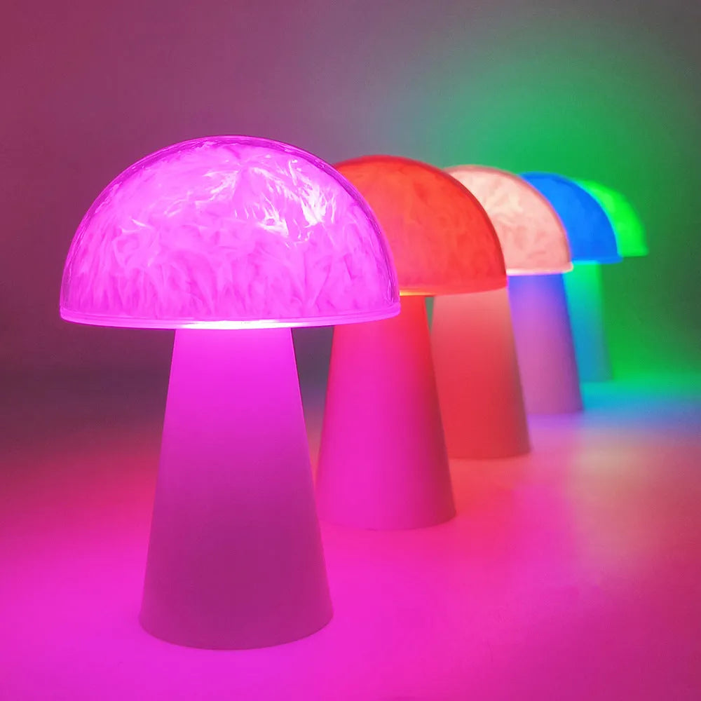 Colourful mushroom-shaped night lamp with remote control on a wooden surface.