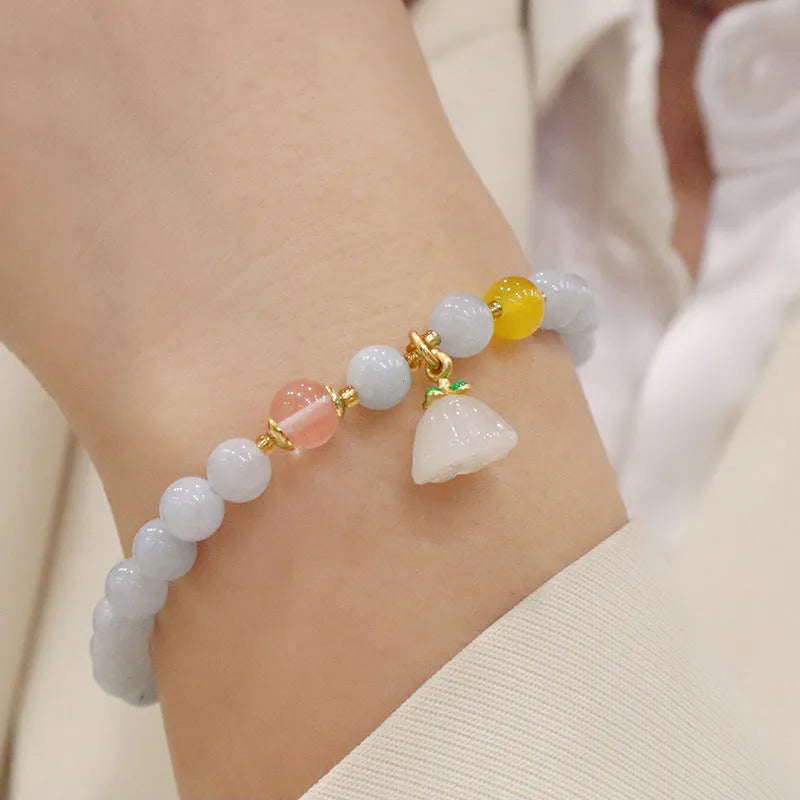 Women's gold plated crystal bracelet with aquamarine chalcedony charm on wrist