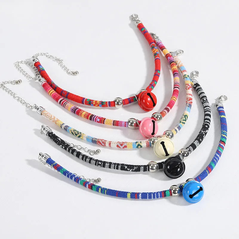 Adjustable dog collar with ethnic patterns and bell in black, blue, pink, red, or white colours, sizes S and L