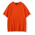 Solid colour loose fit cotton t-shirt with round neck and drop shoulder sleeves on a hanger