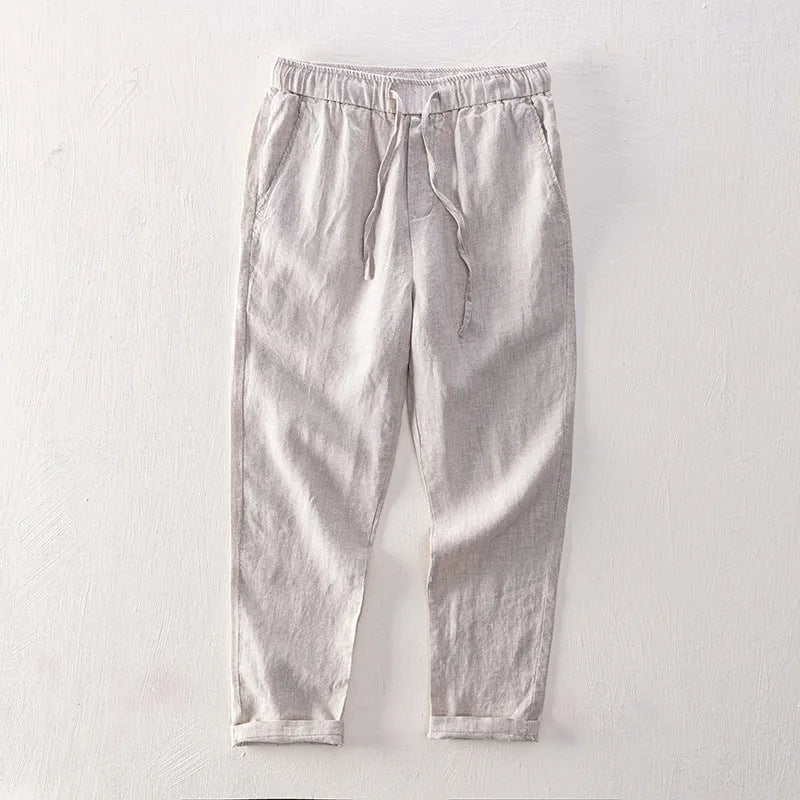 Men's straight-leg linen trousers in dark grey, showing the mid-waist and relaxed leg fit
