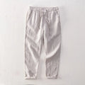 Men's straight-leg linen trousers in dark grey, showing the mid-waist and relaxed leg fit