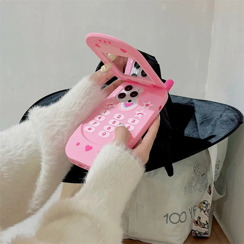 Flip phone shape mirror case for iPhone with silicone construction in light pink colour showing integrated mirror and flip cover design