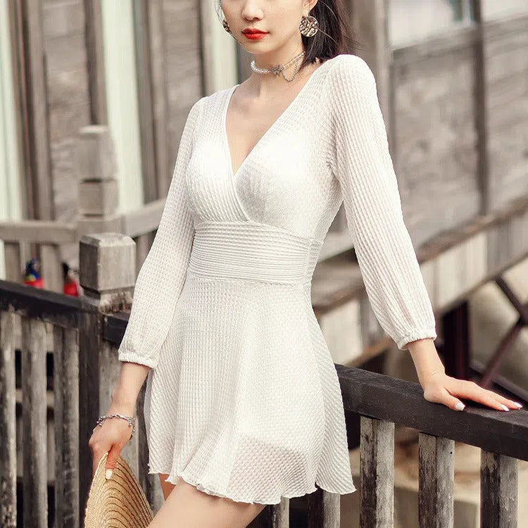 Women's one-piece swimsuit with long sleeves, tummy hiding cut, push up design, in white or black.