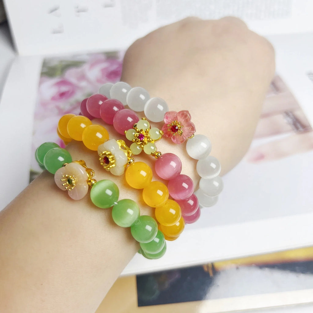 Handmade glass bead bracelet with floral designs in green, pink, white, or yellow colours