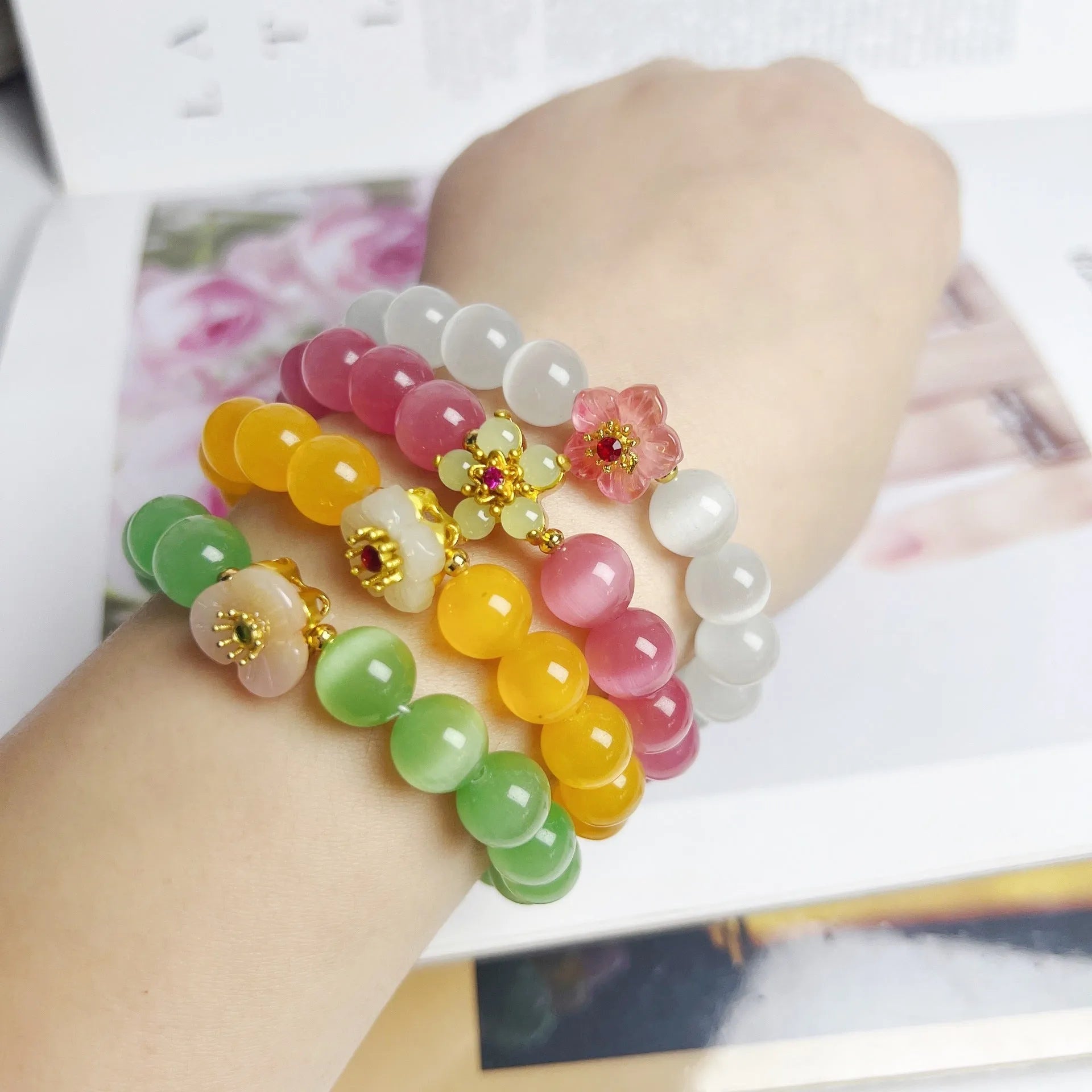 Handmade glass bead bracelet with floral designs in green, pink, white, or yellow colours