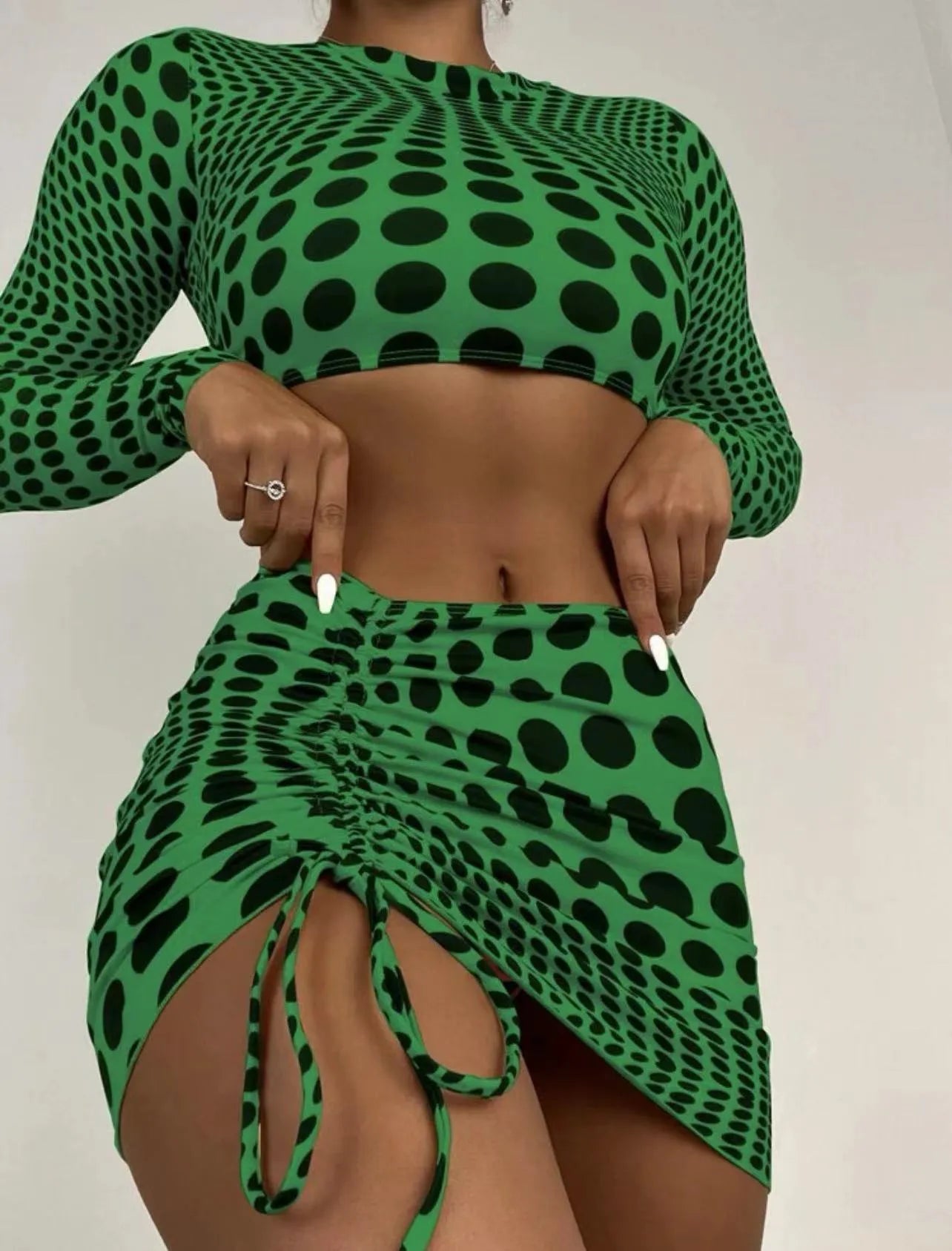 Women's green polka dot three-piece swimsuit set showing top, skirt and bra