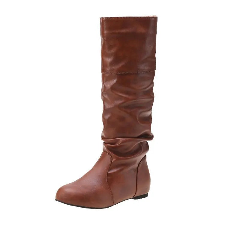 Women's flat heel slip-on boots in black with round toe and high cylinder length, showcasing non-slip rubber sole.