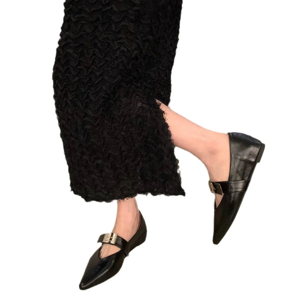Women's black pointed toe Mary Jane shoes with a silver buckle and a low flat heel.