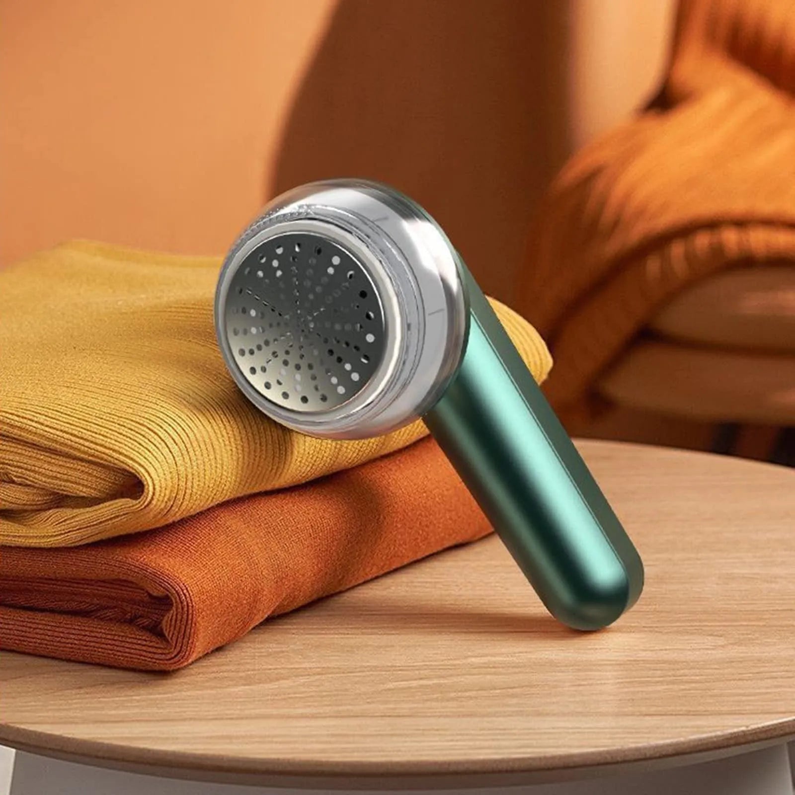 White USB rechargeable electric lint remover shaver with removable lint collector container on a sweater.