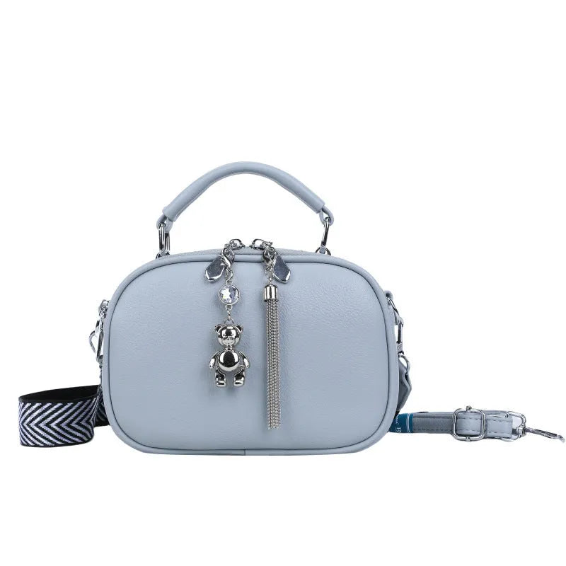 Oval-shaped women's small square bag in PU with double shoulder strap and internal phone pocket.