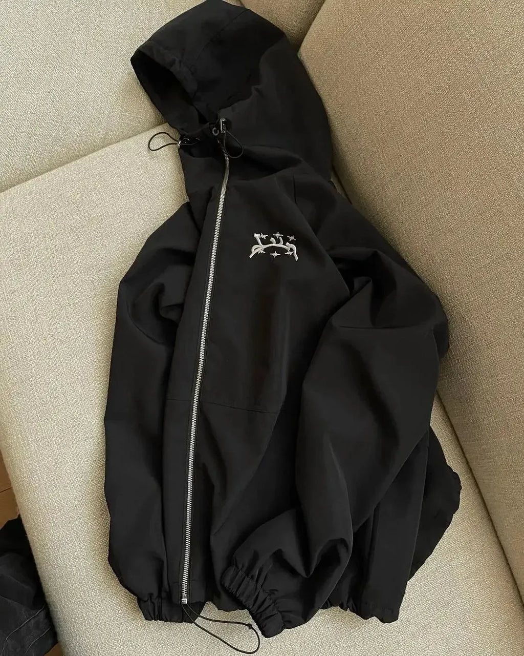 A grey men's hooded loose-fit casual jacket on a hanger.